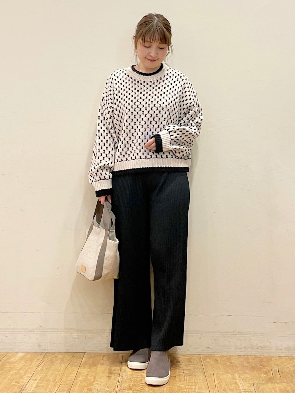 ベージュ系のニット/セーター、ブラック系のその他パンツ、ベージュ系のトートバッグを着用したレディースの秋コーディネートの1枚目の写真