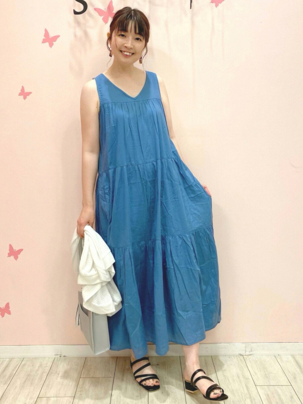 ブルー系のワンピース、ホワイト系のカーディガン/ボレロ、シルバー系のショルダーバッグを着用したレディースの夏コーディネートの1枚目の写真