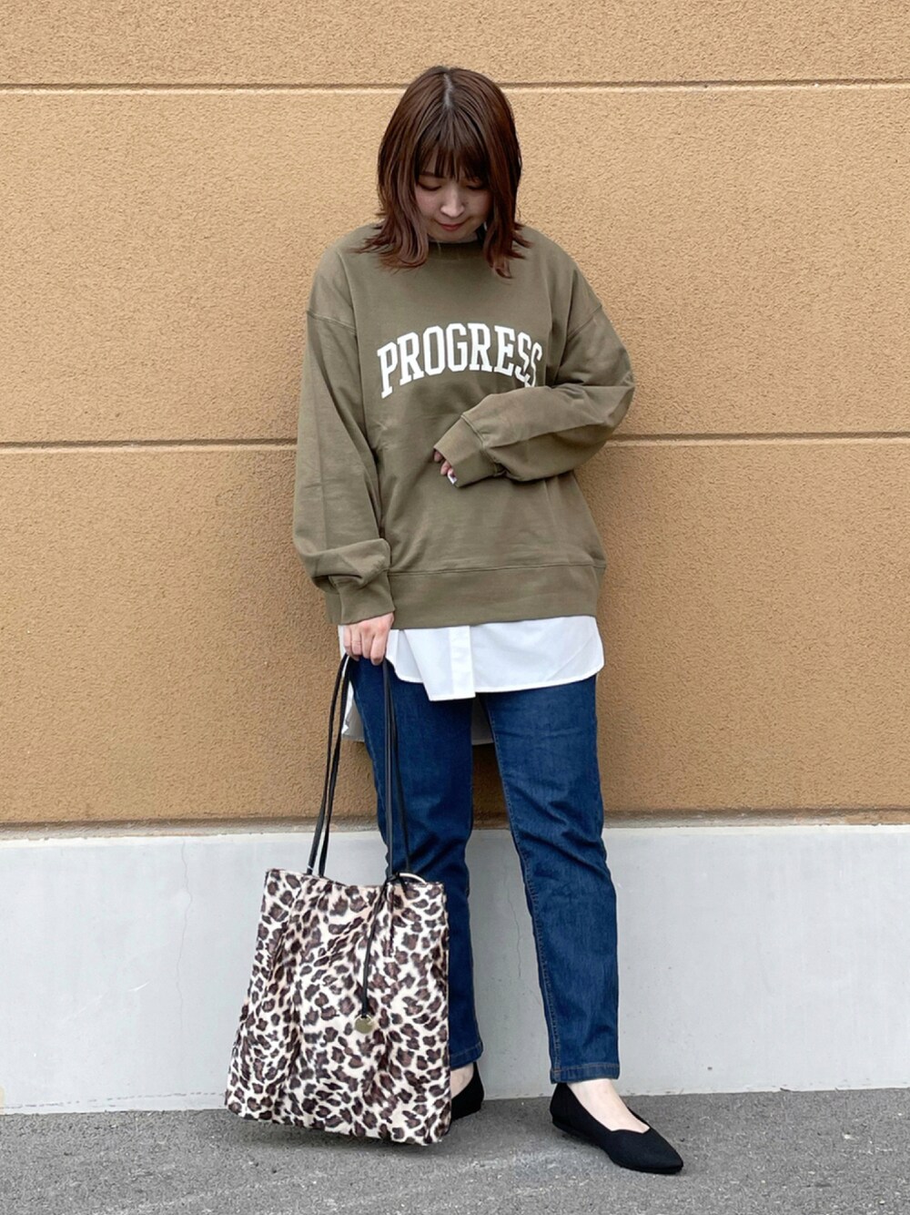 グリーン系のスウェット、ホワイト系のトップス、ブルー系のその他パンツを着用したレディースの秋コーディネートの1枚目の写真