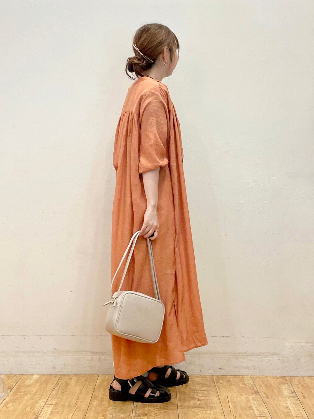 オレンジ系のワンピース、ブラック系のTシャツ/カットソー、ホワイト系のその他パンツを着用したレディースの夏コーディネートの1枚目の写真