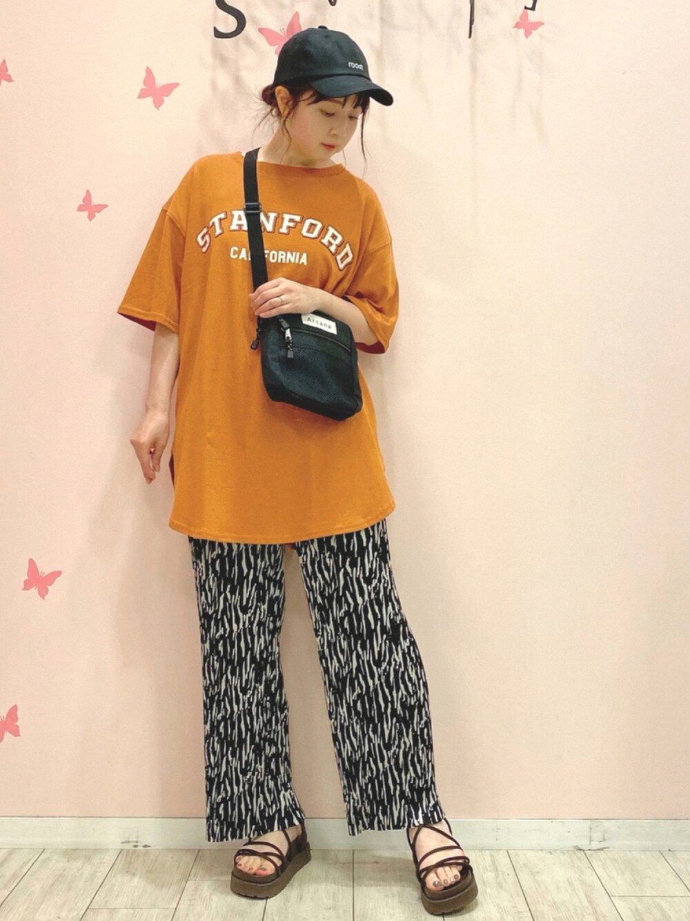 オレンジ系のワンピース、ブラック系のその他パンツ、ブラック系のショルダーバッグを着用したレディースの夏コーディネートの1枚目の写真
