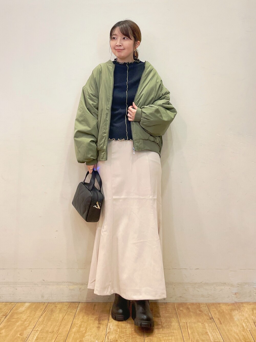 ブラック系のTシャツ/カットソー、ホワイト系のスカート、ブラック系のショルダーバッグを着用したレディースの秋コーディネートの1枚目の写真