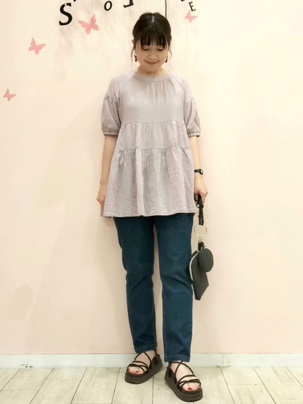 パープル系のシャツ/ブラウス、ブルー系のその他パンツ、ブラック系のショルダーバッグを着用したレディースの夏コーディネートの1枚目の写真