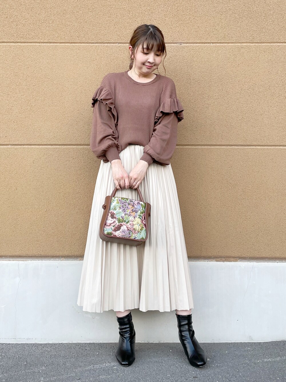 ブラウン系のニット/セーター、ベージュ系のスカート、ベージュ系のトートバッグを着用したレディースの秋コーディネートの1枚目の写真