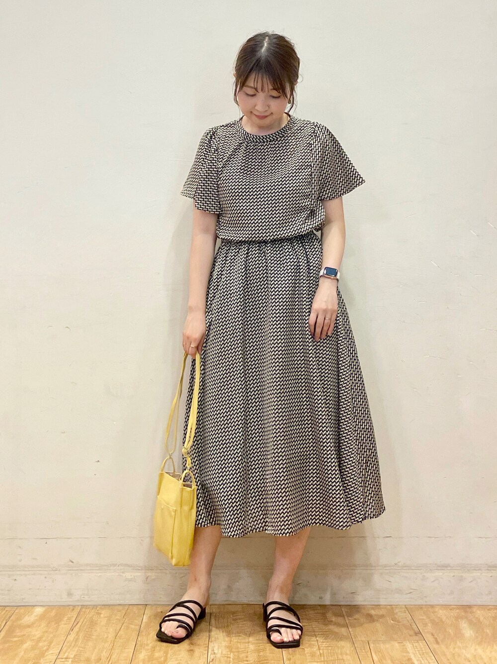 ブラック系のワンピース、イエロー系のショルダーバッグ、ブラック系のサンダルを着用したレディースの夏コーディネートの1枚目の写真