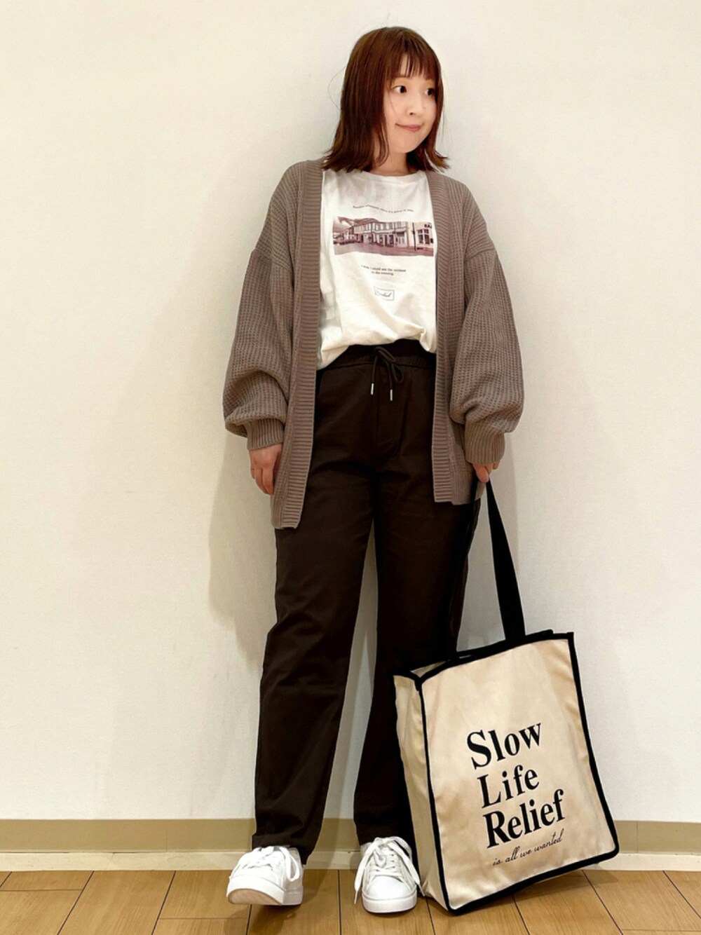ブラウン系のカーディガン/ボレロ、ホワイト系のTシャツ/カットソー、ブラウン系のその他パンツを着用したレディースの秋コーディネートの1枚目の写真