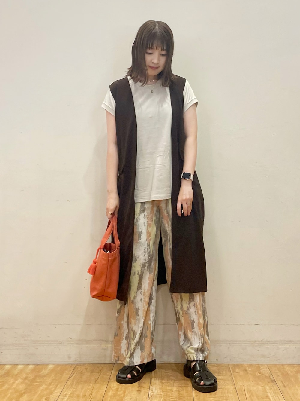 ベージュ系のTシャツ/カットソー、ブラウン系のベスト、レッド系のその他パンツを着用したレディースの夏コーディネートの1枚目の写真