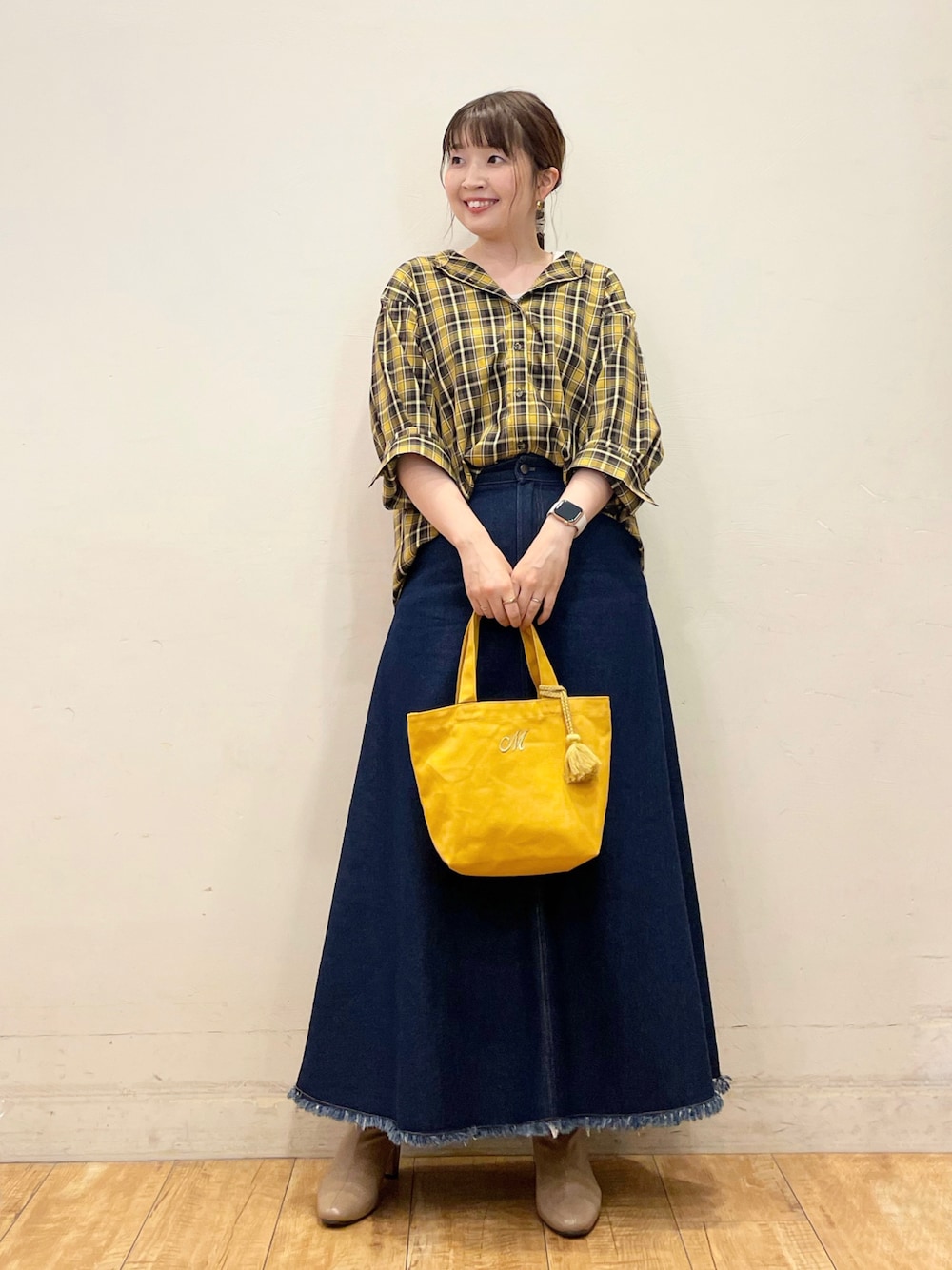 イエロー系のシャツ/ブラウス、ベージュ系のタンクトップ、ブルー系のデニムスカートを着用したレディースの秋コーディネートの1枚目の写真