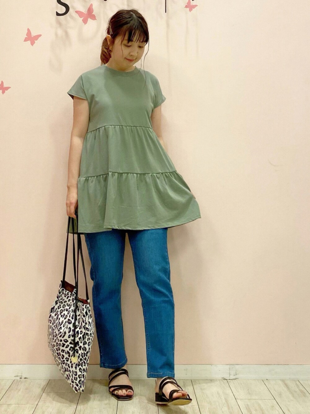 グリーン系のチュニック、ブルー系のその他パンツ、ブラック系のトートバッグを着用したレディースの夏コーディネートの1枚目の写真