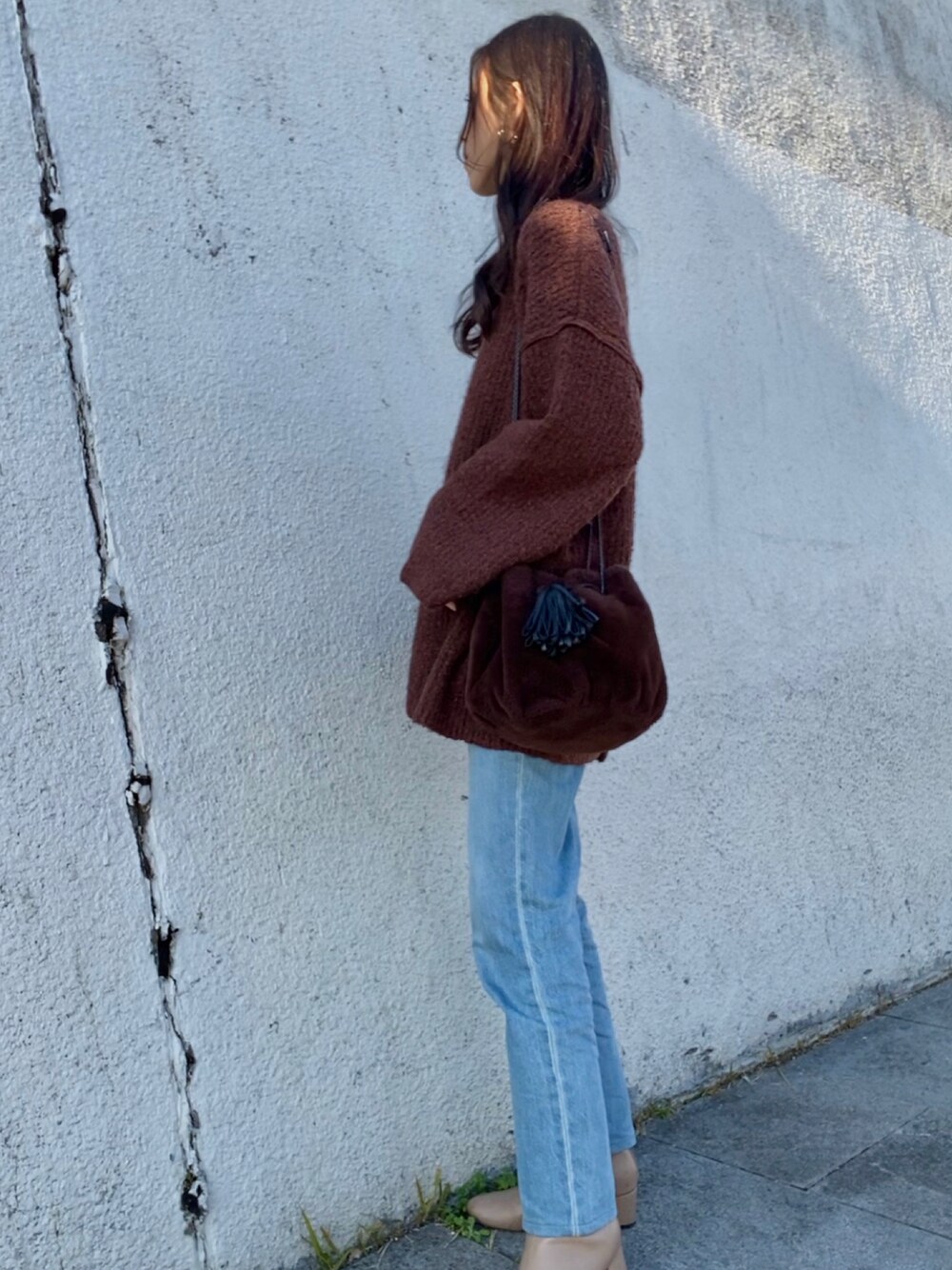 ブラウン系のニット/セーター、ブルー系のデニムパンツ、ベージュ系のブーツを着用したレディースの冬コーディネートの1枚目の写真