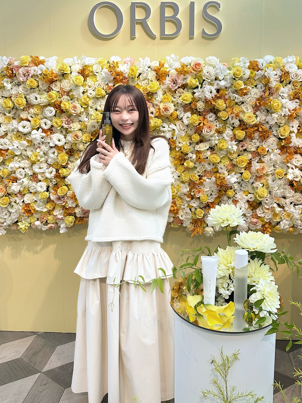 ホワイト系のニット/セーター、ベージュ系のスカート、ブラウン系のブーツを着用したレディースの秋コーディネートの1枚目の写真