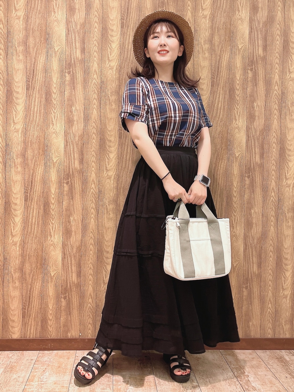 ブルー系のシャツ/ブラウス、ブラック系のスカート、ホワイト系のトートバッグを着用したレディースの夏コーディネートの1枚目の写真