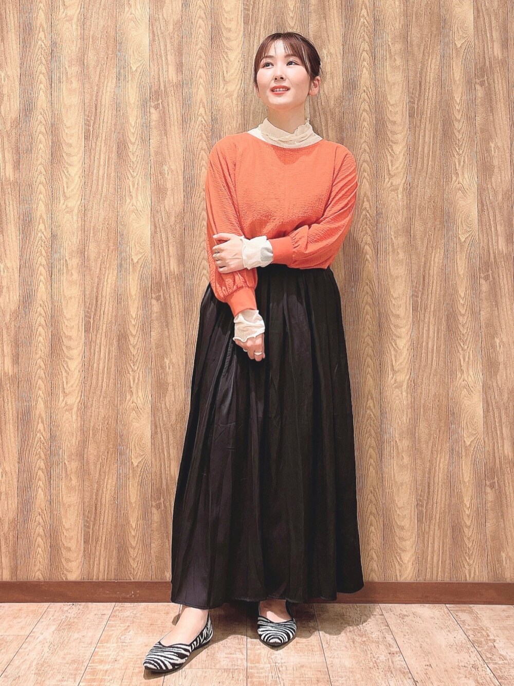 オレンジ系のシャツ/ブラウス、ベージュ系のTシャツ/カットソー、グレー系のスカートを着用したレディースの春コーディネートの1枚目の写真