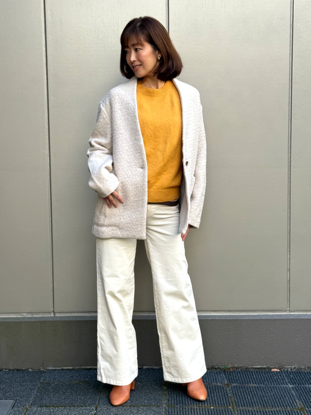 ホワイト系のその他パンツ、ホワイト系のノーカラーコート、イエロー系のニット/セーターを着用したレディースの秋コーディネートの1枚目の写真