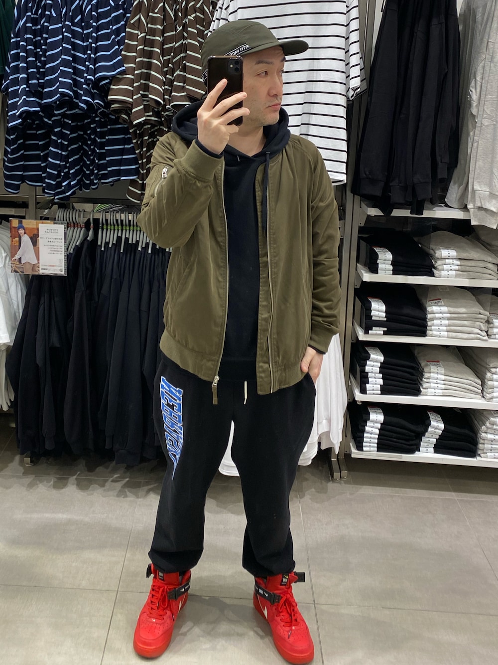 ブラック系のパーカー、グリーン系のMA-1、ブラック系のスウェットパンツを着用したメンズの春コーディネートの1枚目の写真