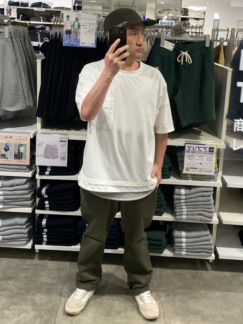 グリーン系のチノパンツ、ベージュ系のスニーカー、ホワイト系のTシャツ/カットソーを着用したメンズの夏コーディネートの1枚目の写真