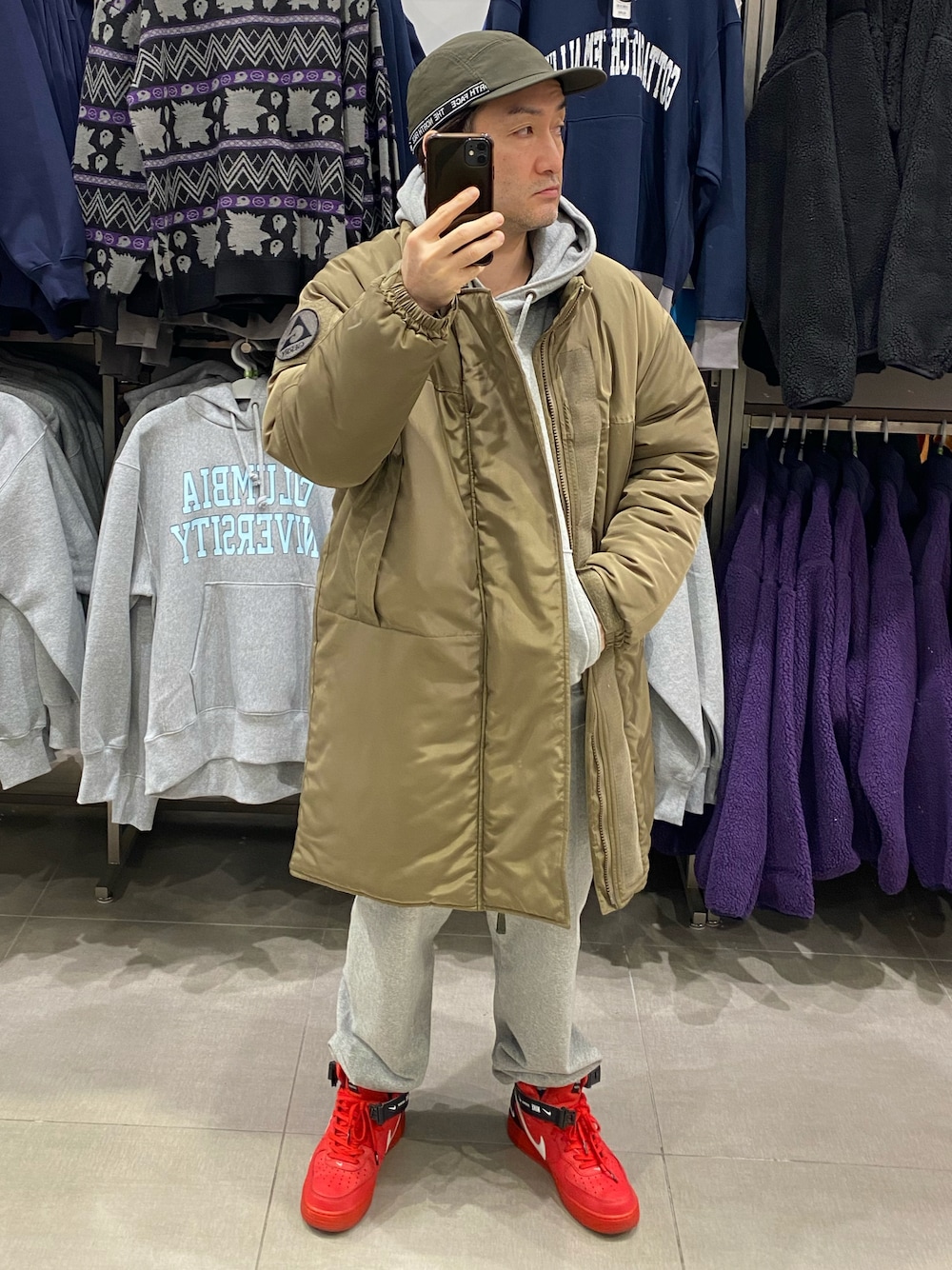 グリーン系のダウンジャケット/コート、グレー系のカーゴパンツ、レッド系のスニーカーを着用したメンズの冬コーディネートの1枚目の写真