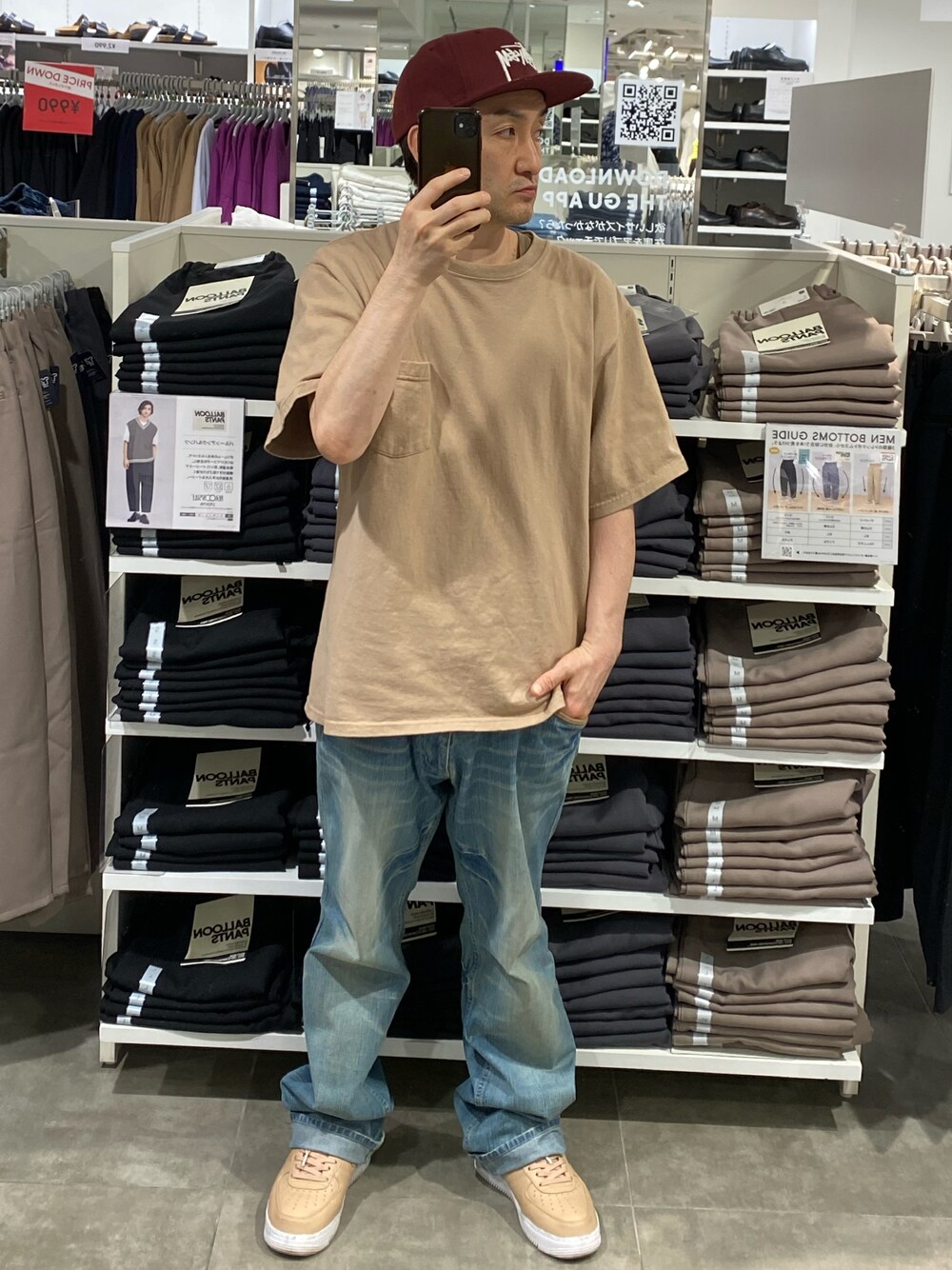 ベージュ系のTシャツ/カットソー、ブルー系のデニムパンツ、ベージュ系のスニーカーを着用したメンズの秋コーディネートの1枚目の写真