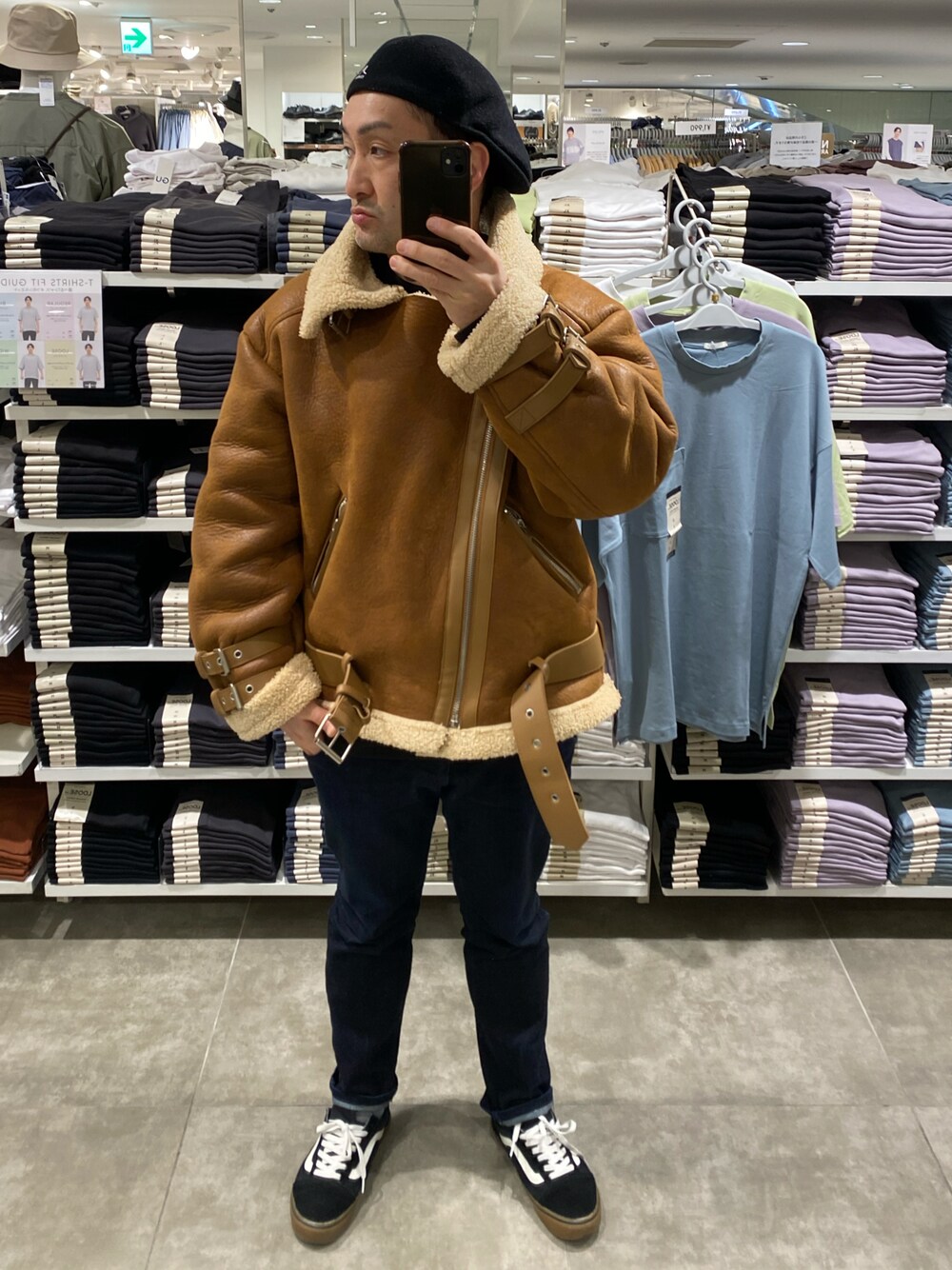 ブラウン系のムートンコート、ブルー系のデニムパンツ、ブラック系のスニーカーを着用したメンズの冬コーディネートの1枚目の写真