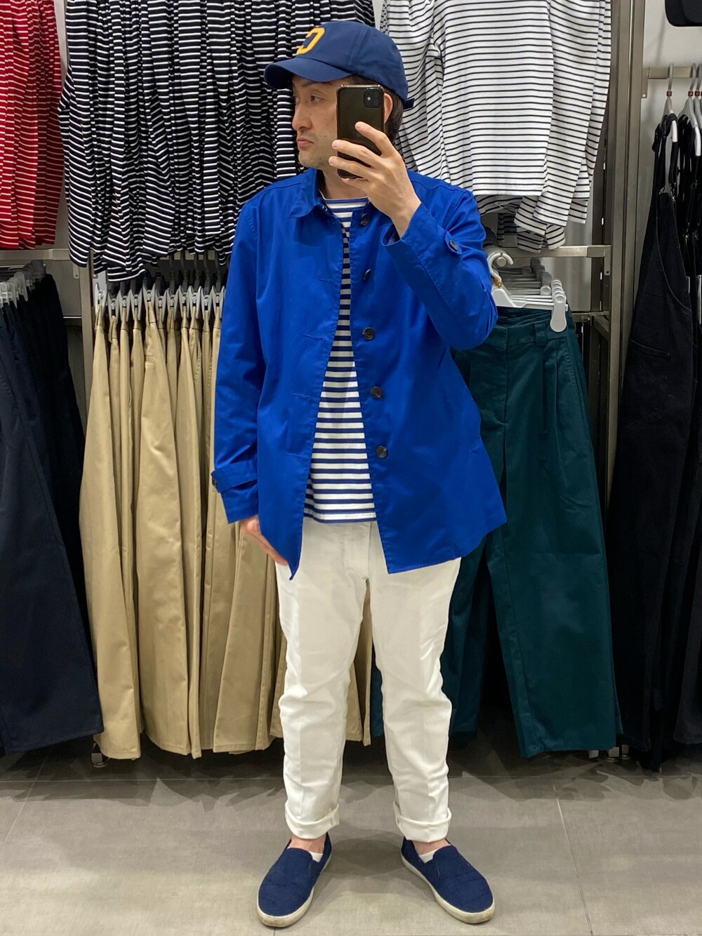 ブルー系のステンカラーコート、ブルー系のステンカラーコート、ホワイト系のデニムパンツを着用したメンズの春コーディネートの1枚目の写真