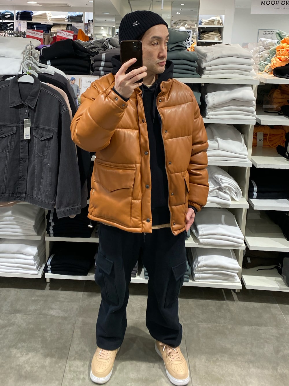 ブラウン系のダウンジャケット/コート、ブラック系のカーゴパンツ、ベージュ系のスニーカーを着用したメンズの冬コーディネートの1枚目の写真