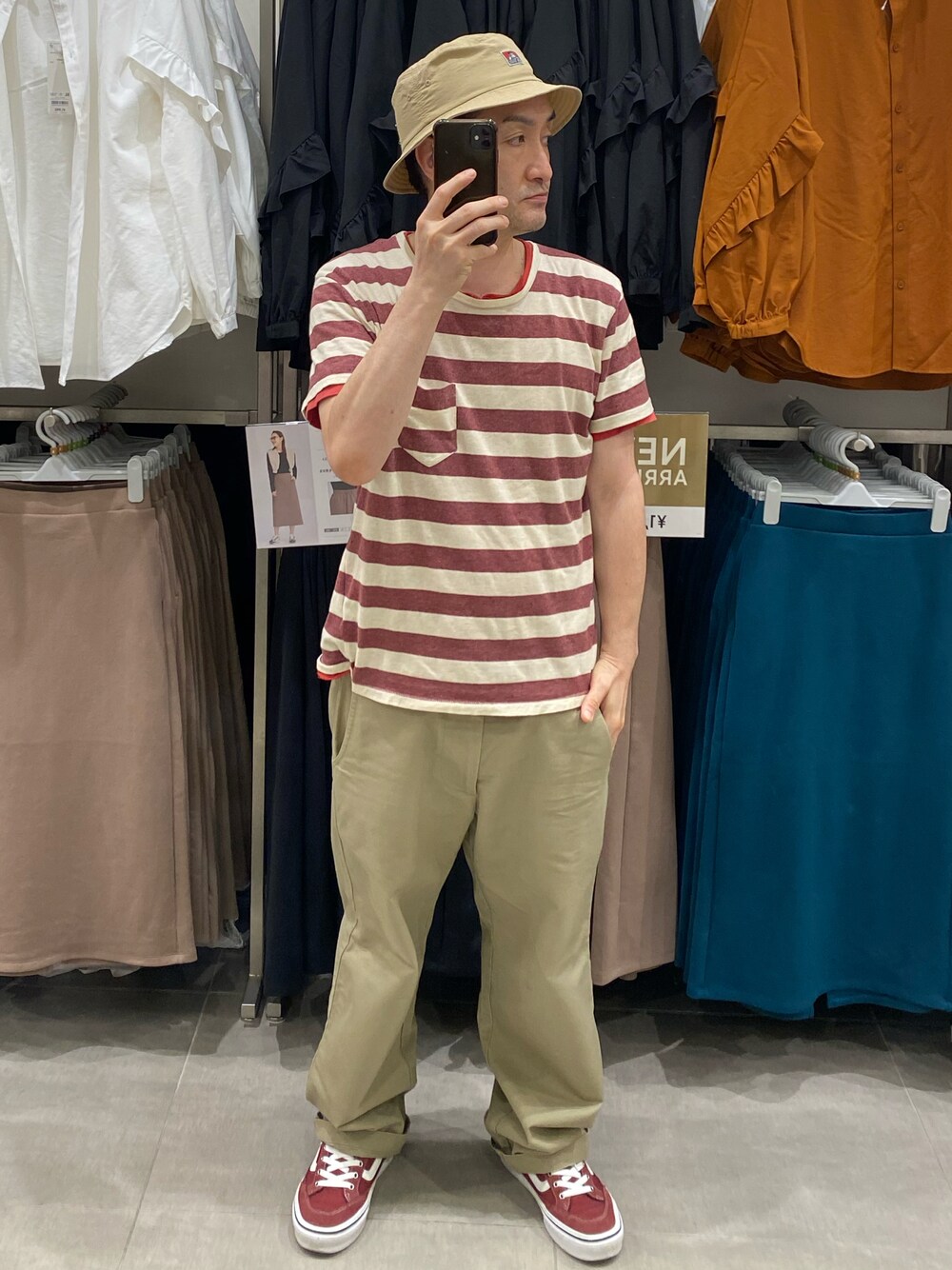 ベージュ系のチノパンツ、レッド系のスニーカー、その他のTシャツ/カットソーを着用したメンズの夏コーディネートの1枚目の写真