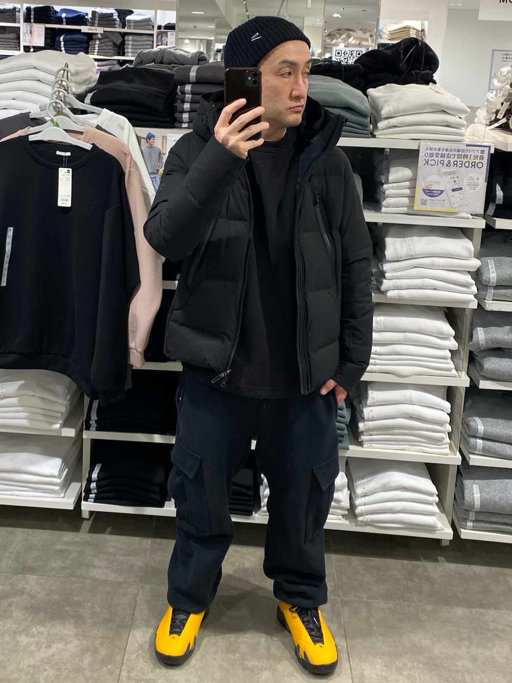 ブラック系のダウンジャケット/コート、ブラック系のスウェット、ブラック系のカーゴパンツを着用したメンズの冬コーディネートの1枚目の写真
