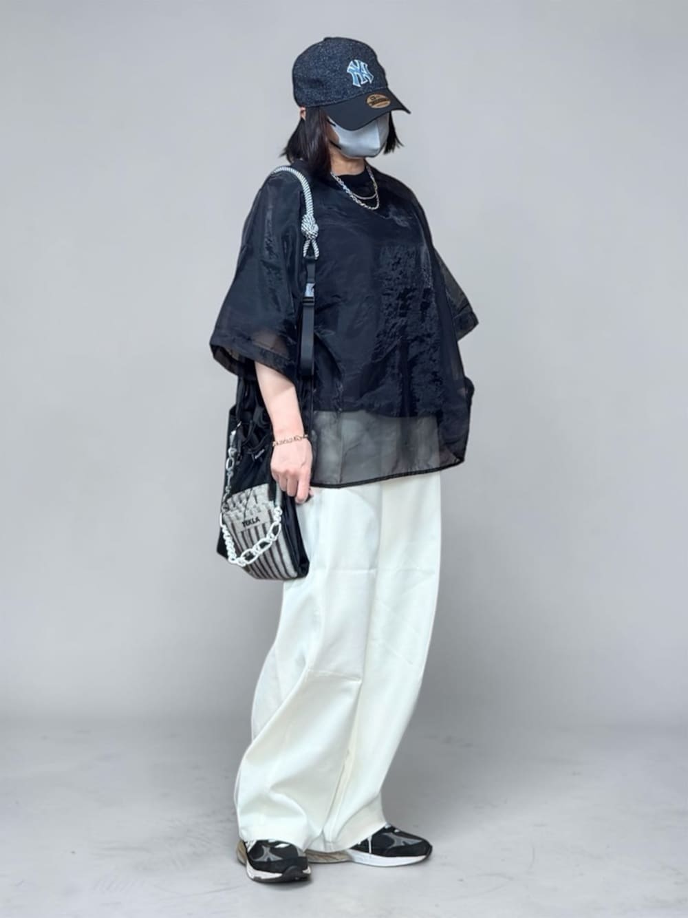 ブラック系のTシャツ/カットソー、ブラック系のエコバッグ/サブバッグ、ホワイト系のその他パンツを着用したレディースの春コーディネートの1枚目の写真