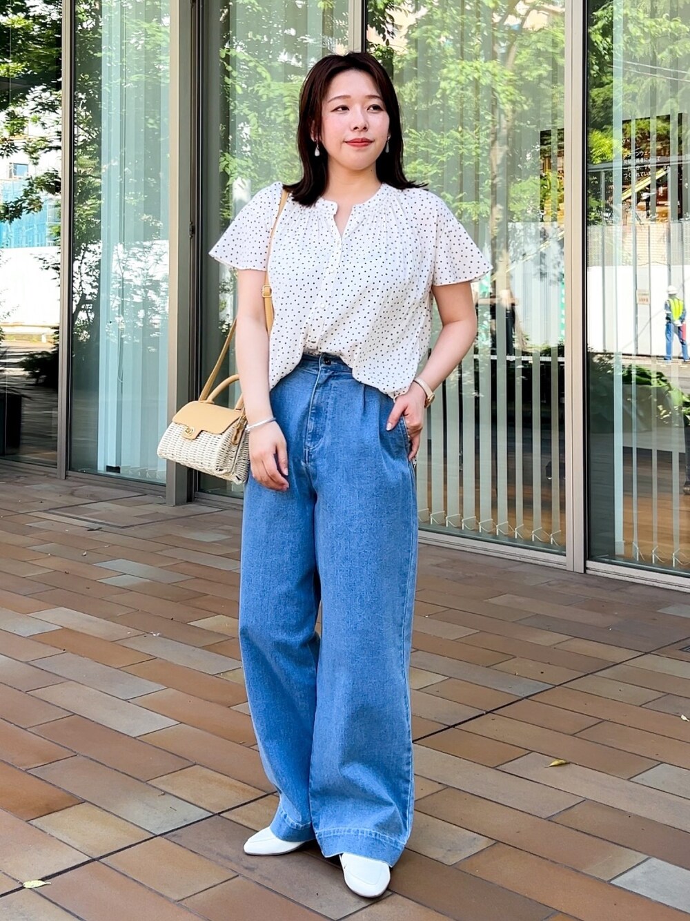 イエロー系のショルダーバッグ、ホワイト系のシャツ/ブラウス、ブルー系のデニムパンツを着用したレディースの春コーディネートの1枚目の写真