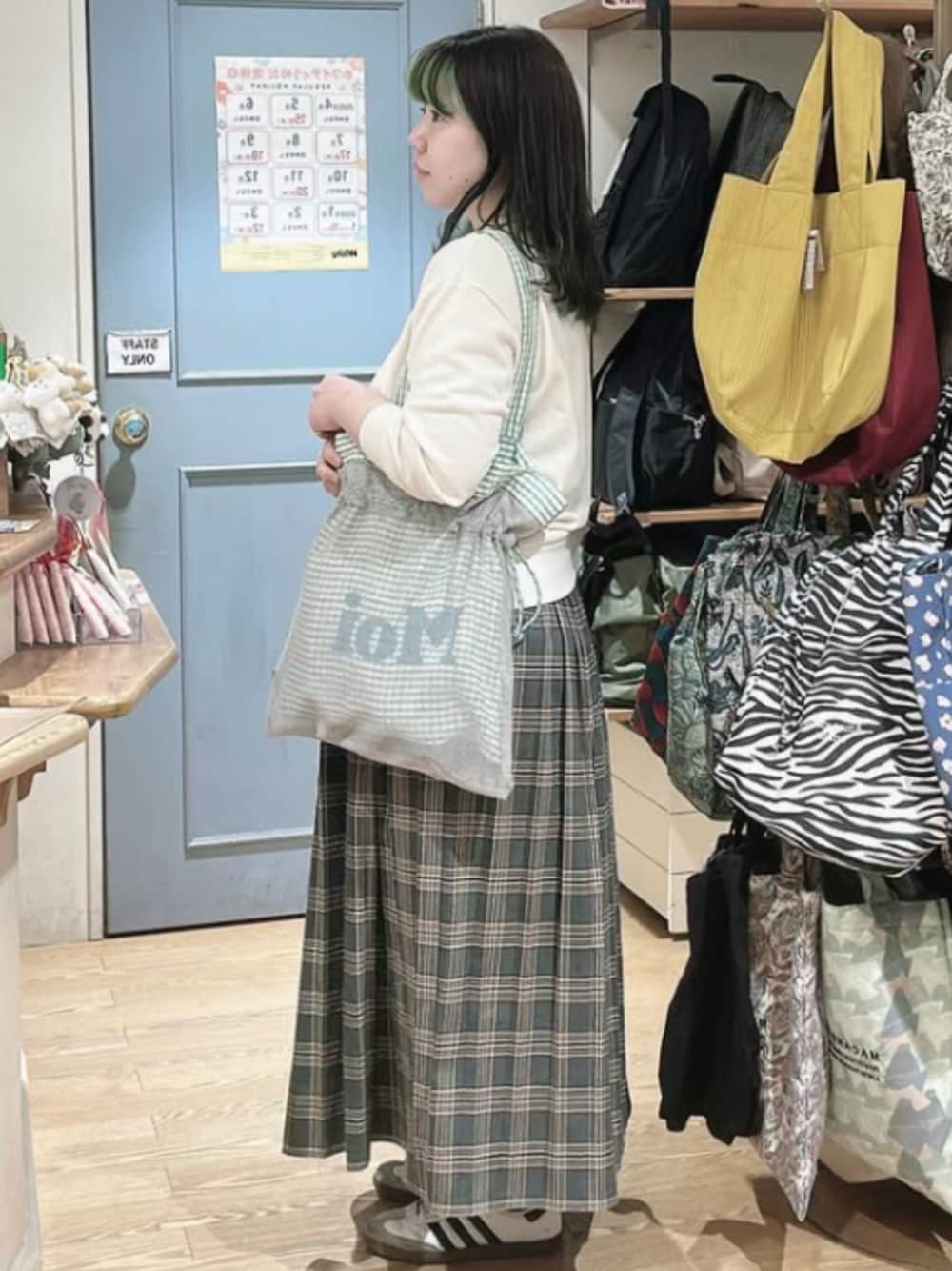 グリーン系のトートバッグを着用したレディースの冬コーディネートの1枚目の写真