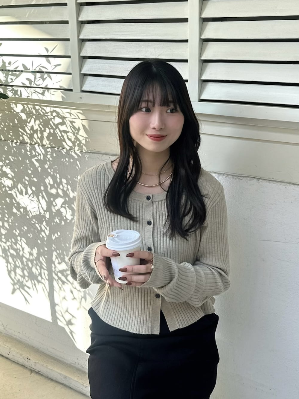 ベージュ系のニット/セーター、ブラック系のスカートを着用したレディースの冬コーディネートの1枚目の写真