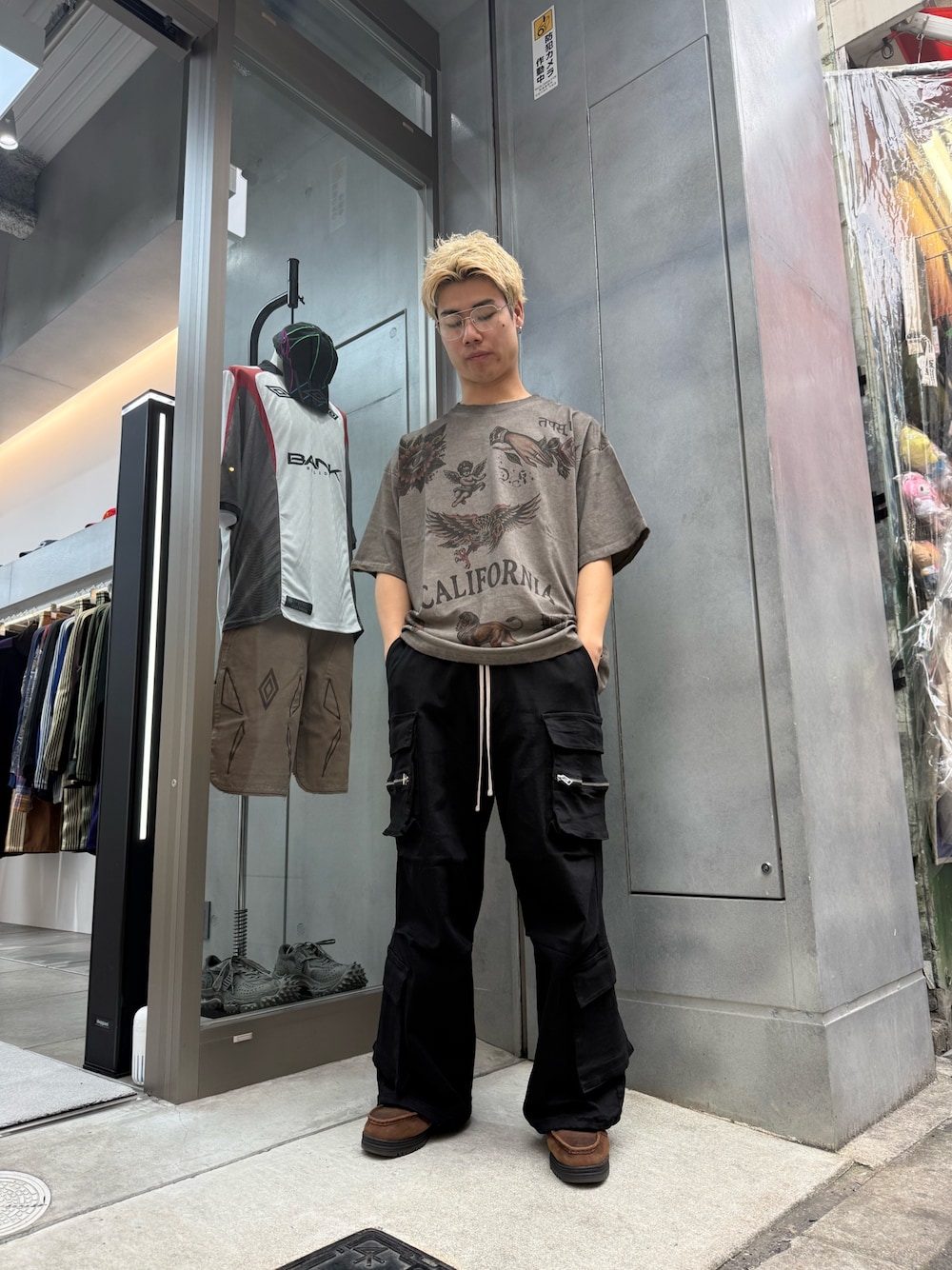 ブラック系のカーゴパンツ、ベージュ系のTシャツ/カットソーを着用したメンズの夏コーディネートの1枚目の写真