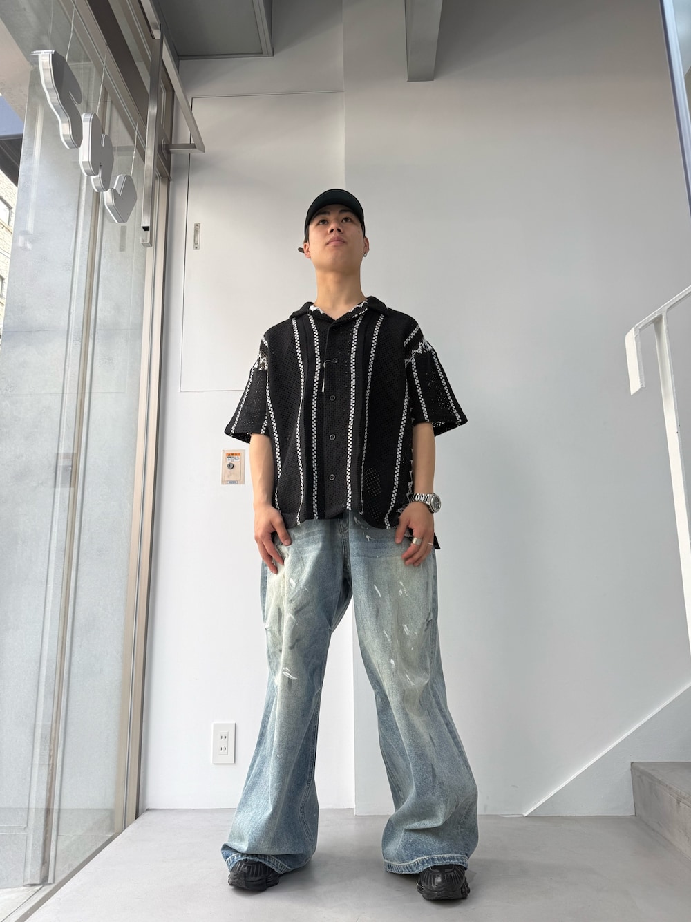 ブラック系のシャツ/ブラウス、ブルー系のデニムパンツを着用したメンズの春コーディネートの1枚目の写真