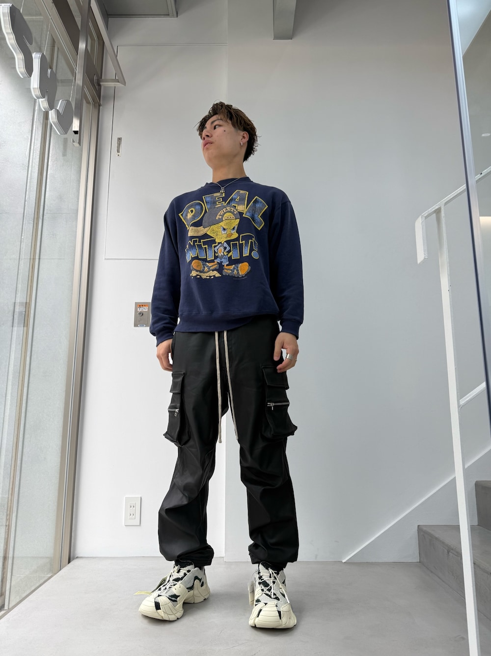 ブラック系のカーゴパンツを着用したメンズの春コーディネートの1枚目の写真