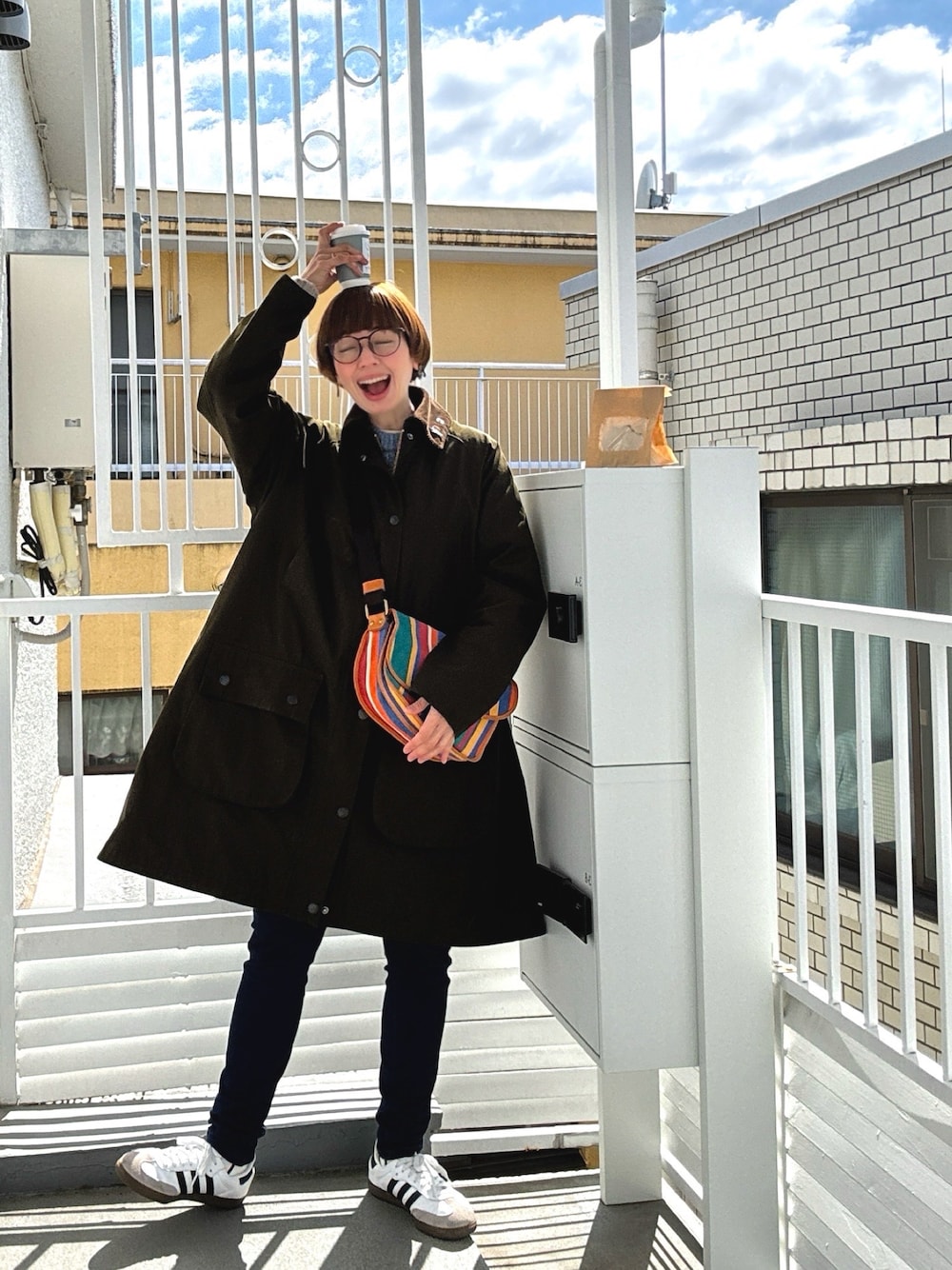 その他のショルダーバッグ、グリーン系のその他アウター、ホワイト系のスニーカーを着用したレディースの春コーディネートの1枚目の写真