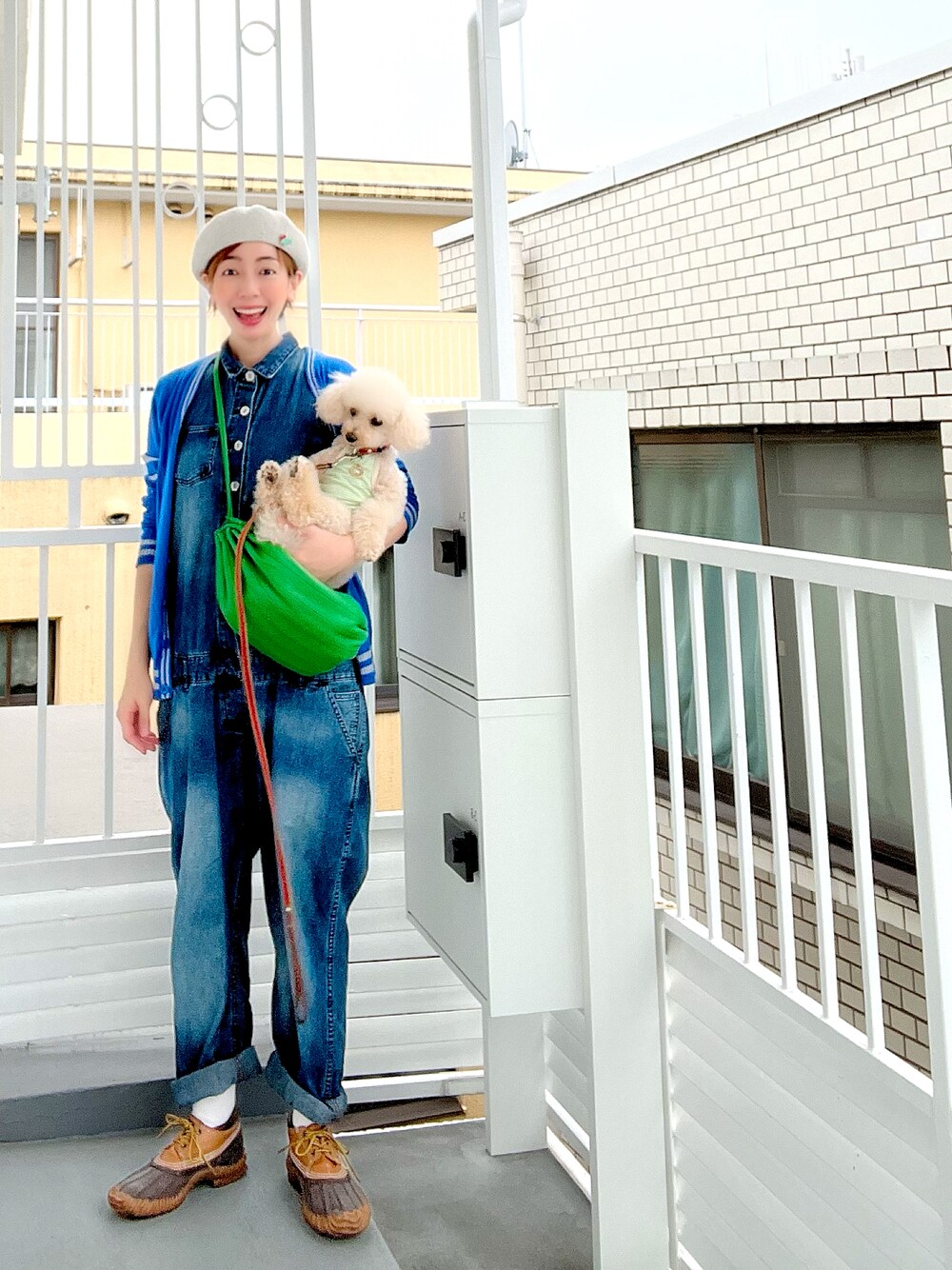 ブルー系のつなぎ/オールインワン、グリーン系のショルダーバッグ、グレー系のレインシューズを着用したレディースの秋コーディネートの1枚目の写真