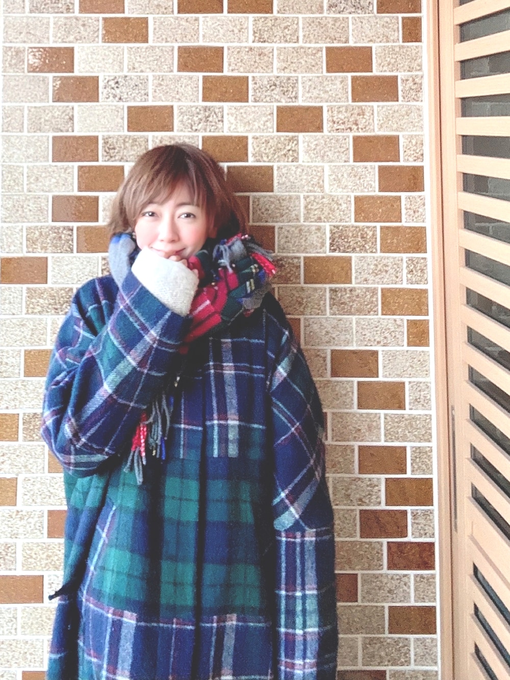 グリーン系のその他アウター、グレー系のストール/ショール、ホワイト系のペットウェアを着用したレディースの冬コーディネートの1枚目の写真