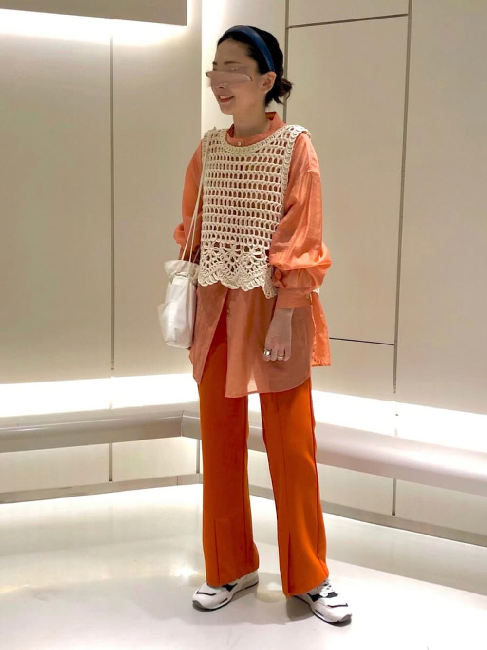 オレンジ系のシャツ/ブラウス、ホワイト系のベスト、ホワイト系のショルダーバッグを着用したレディースの夏コーディネートの1枚目の写真