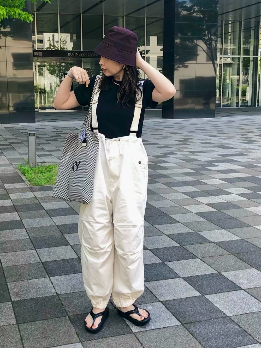 ホワイト系のサロペット/オーバーオール、ブラック系のTシャツ/カットソー、ブラック系のサンダルを着用したレディースの夏コーディネートの1枚目の写真