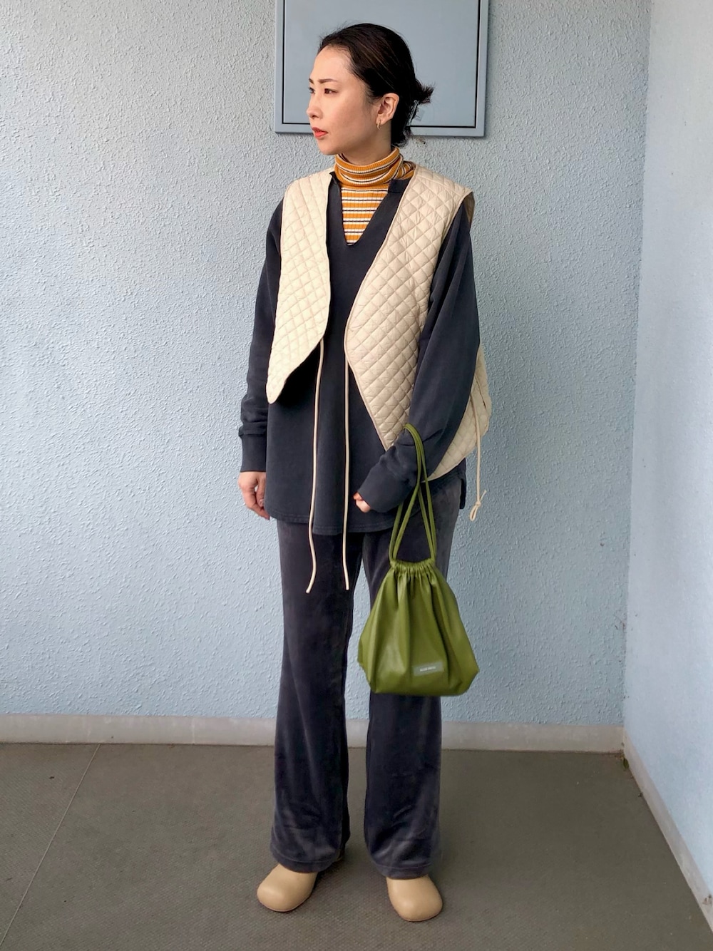 ホワイト系のベスト、グレー系のスウェット、イエロー系のニット/セーターを着用したレディースの冬コーディネートの1枚目の写真