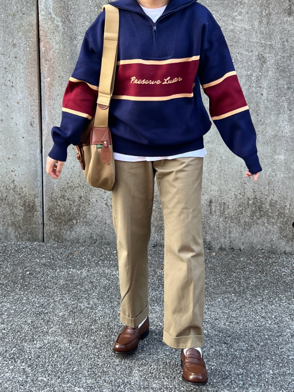 ブルー系のニット/セーター、ベージュ系のチノパンツ、ブラウン系のローファーを着用したレディースの冬コーディネートの1枚目の写真