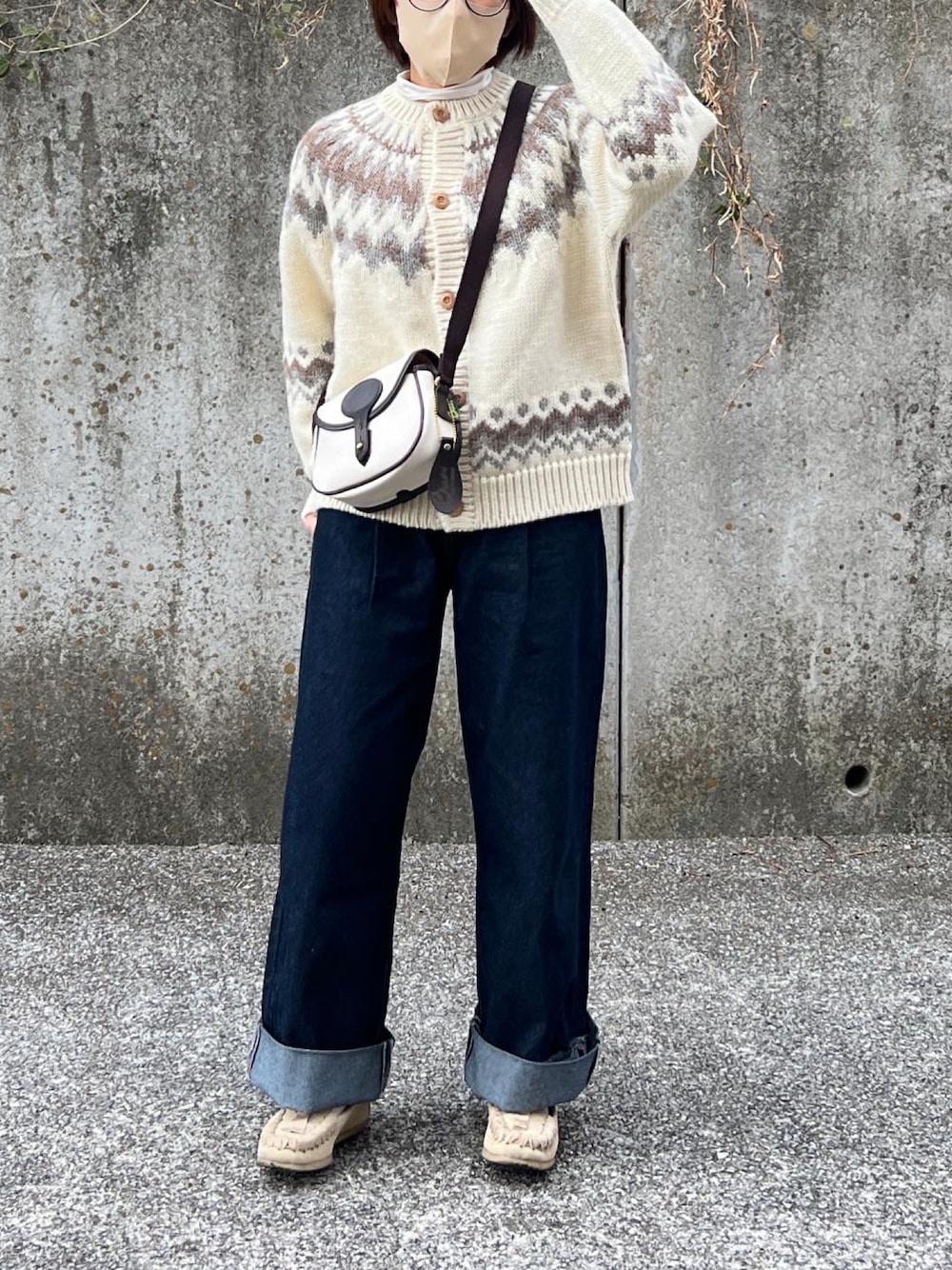 ブルー系のデニムパンツ、ホワイト系のショルダーバッグ、ベージュ系のその他シューズを着用したレディースの冬コーディネートの1枚目の写真