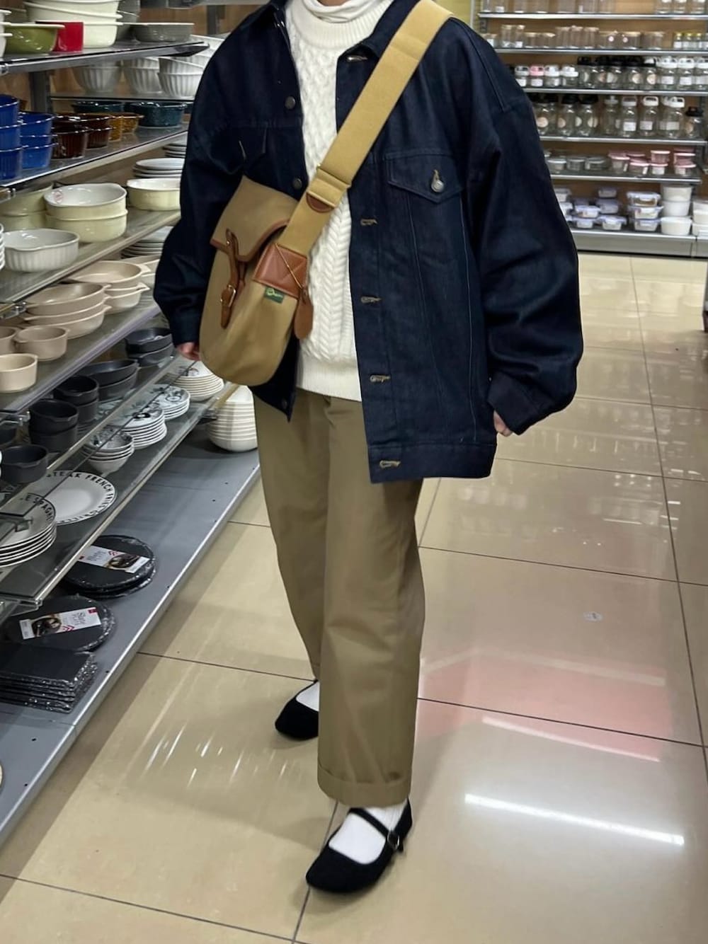 ブルー系のデニムジャケット、グリーン系のショルダーバッグ、ベージュ系のチノパンツを着用したレディースの冬コーディネートの1枚目の写真