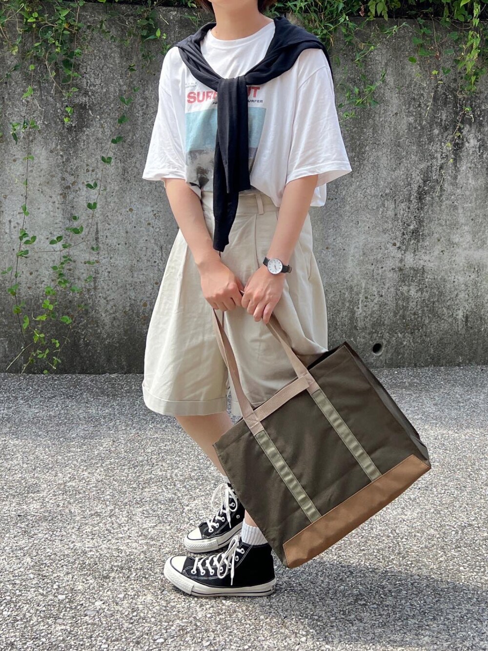 ホワイト系のTシャツ/カットソー、ベージュ系のパンツ、ブラック系のスニーカーを着用したレディースの秋コーディネートの1枚目の写真