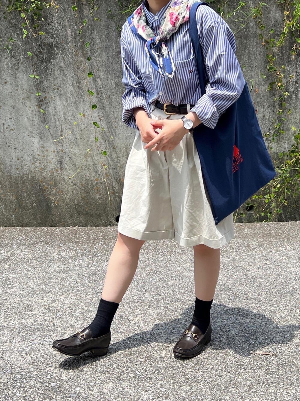 ベージュ系のパンツ、ブルー系のトートバッグを着用したレディースの夏コーディネートの1枚目の写真