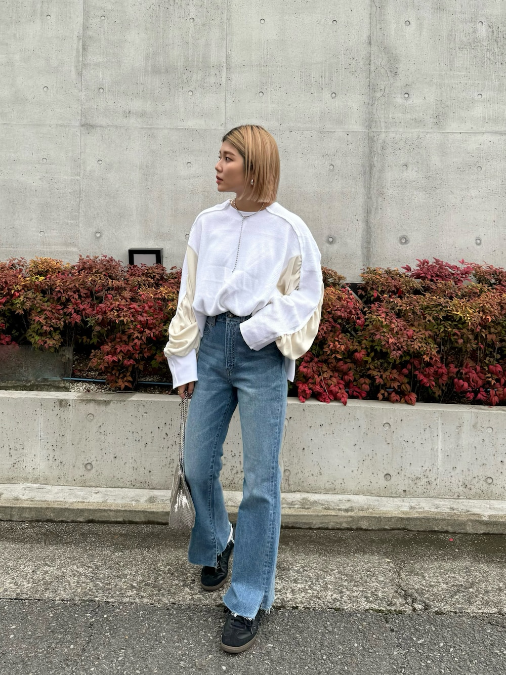ホワイト系のTシャツ/カットソー、ブルー系のデニムパンツ、ブラック系のスニーカーを着用したレディースの冬コーディネートの1枚目の写真