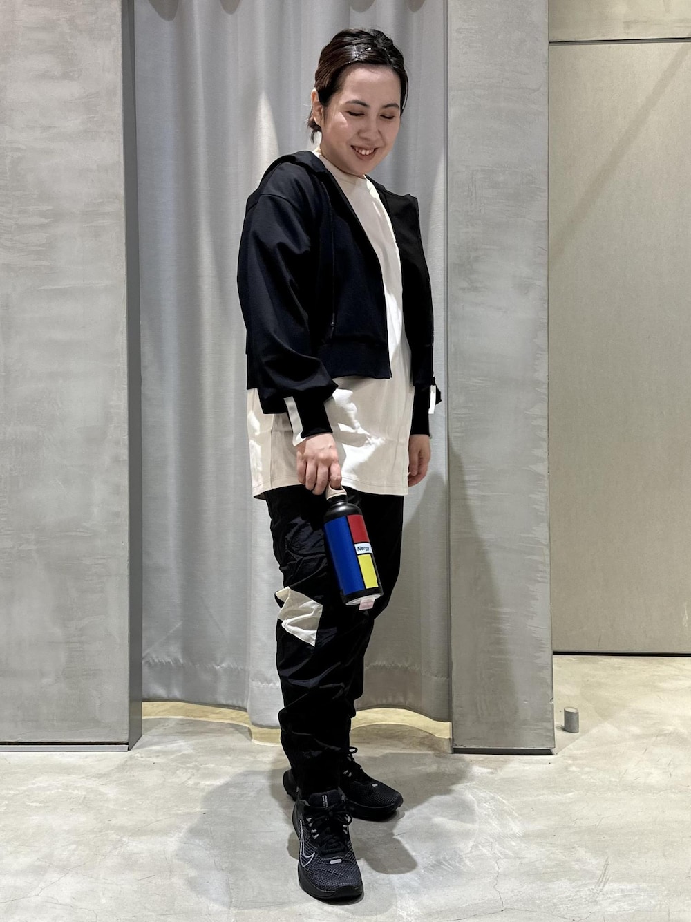 ブラック系のパーカー、ベージュ系のTシャツ/カットソー、ブラック系のスニーカーを着用したレディースの冬コーディネートの1枚目の写真