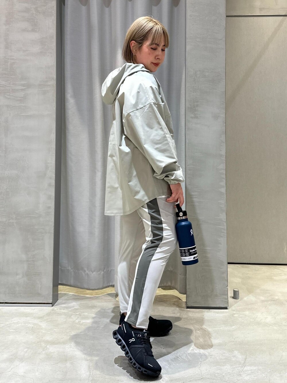 グリーン系のパーカー、グレー系のその他パンツ、ブラック系のスニーカーを着用したレディースの春コーディネートの1枚目の写真