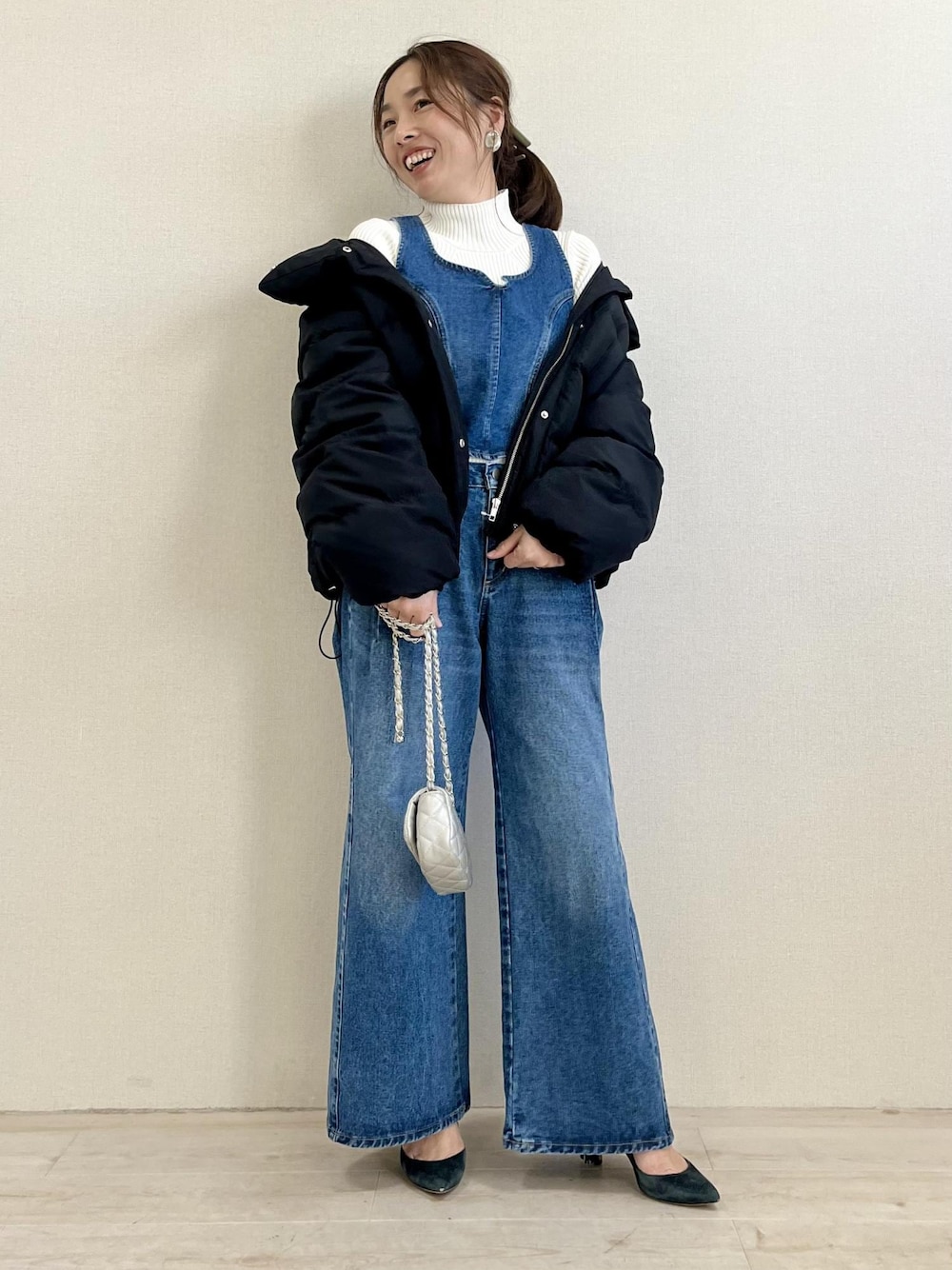 ブラック系のダウンジャケット/コート、シルバー系のショルダーバッグ、ホワイト系のニット/セーターを着用したレディースの冬コーディネートの1枚目の写真