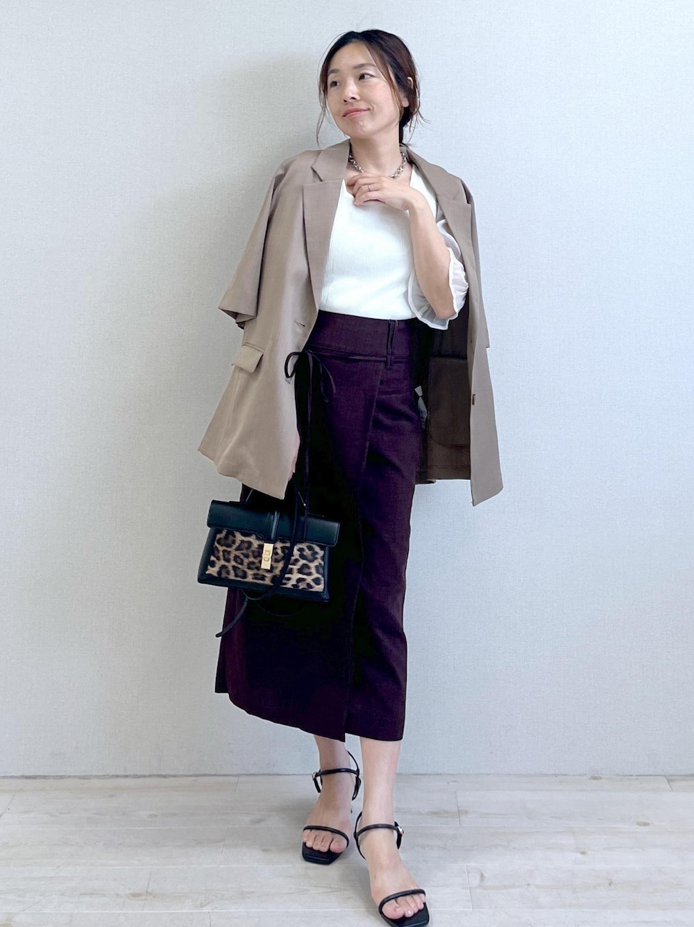 ブラック系のサンダル、ホワイト系のTシャツ/カットソー、ブラウン系のスカートを着用したレディースの夏コーディネートの1枚目の写真